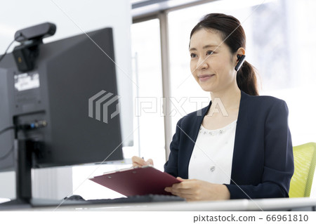 Image of business woman online meeting heading to a desktop computer with a webcam 66961810