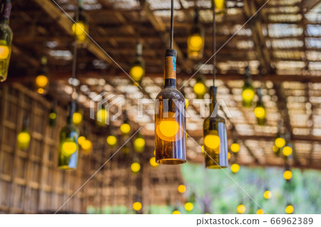 Beautiful retro light lamp decor made of empty wine bottles. Toned Beautiful retro light lamp decor made of empty wine bottles. Toned 66962389
