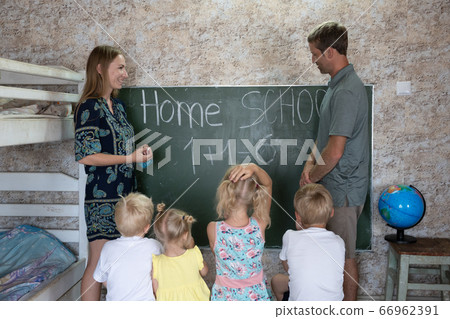Parents teach their children at the blackboard in their home. Home school. Parents teach their children at the blackboard in their home. Home school. 66962391