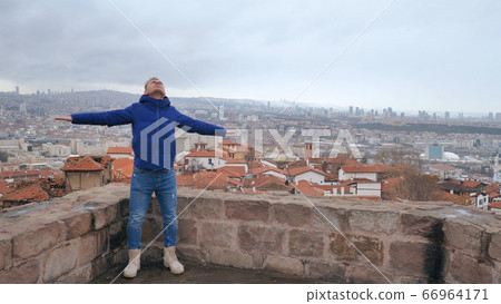 A guy with spread arms admires the capital of Turkey, Ankara. A guy with spread arms admires the capital of Turkey, Ankara. 66964171