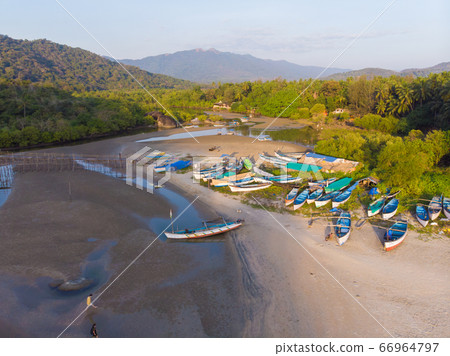 The beautiful nature of the state of Goa near the Palole beach at sunset and fishing boats. India. Drone view. The beautiful nature of the state of Goa near the Palole beach at sunset and fishing boats. India. Drone view. 66964797