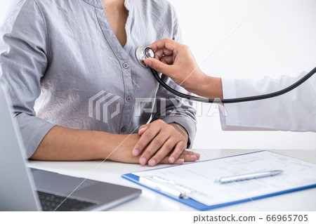 Doctor using a stethoscope checking patient with Doctor using a stethoscope checking patient with 66965705