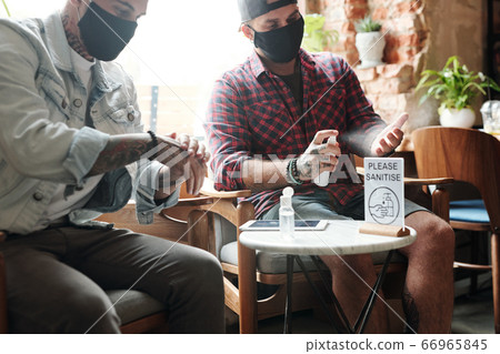 Spraying hands with sanitizer Spraying hands with sanitizer 66965845