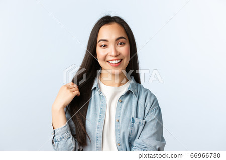 Lifestyle, people emotions and beauty concept. Carefree young asian woman talking and smiling, touching hair, recommend haircare products or beauty salon, white background 66966780