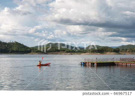 Tourist canoeing on lake in dam with blue sky 66967517