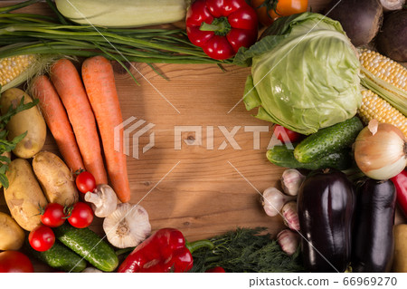 Assortment of fresh raw vegetables on a wooden table. Healthy food Top view background with empty space. 66969270