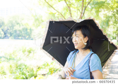 Middle women who take a walk with a parasol Middle women who look good with a parasol 66970435