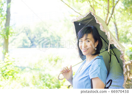 帶著陽傘散步的中年婦女帶著陽傘散步的中年婦女 帶著陽傘散步的中年婦女帶著陽傘散步的中年婦女 66970438