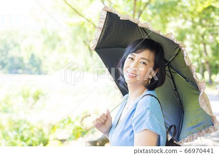 帶著陽傘散步的中年婦女帶著陽傘散步的中年婦女 帶著陽傘散步的中年婦女帶著陽傘散步的中年婦女 66970441