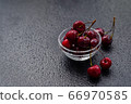 Cherry in dew drops is in a glass bowl 66970585