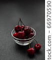 Cherry in dew drops is in a glass bowl 66970590