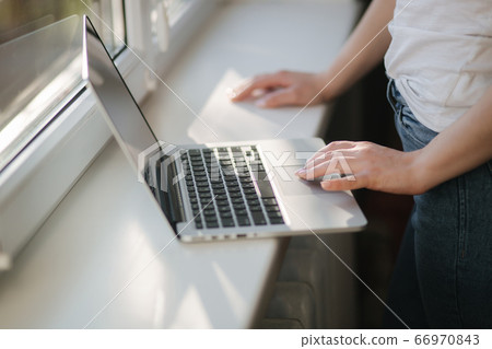 Close up of young woman shopping online using laptop phone and credit card. Laptop on windowsill Close up of young woman shopping online using laptop phone and credit card. Laptop on windowsill 66970843
