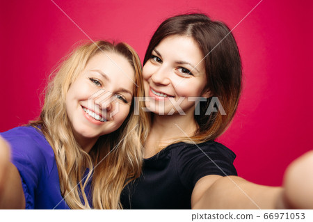 Two positivity girls taking self portrait smiling Two positivity girls taking self portrait smiling 66971053
