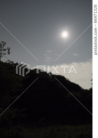 A full moon shining over the mountains 66971326