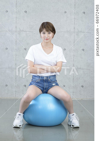 Woman exercising with a balance ball 66972408