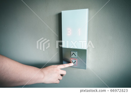 Closeup of Woman Hand is Pressing Elevator Button for Access to Office Building 66972823