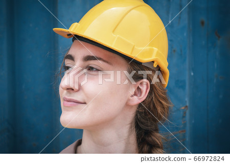 Portrait of Confident Transport Engineer Woman in Safety Equipment Standing in Container Ship Yard 66972824