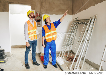 Contractor checking plastered brickwork Contractor checking plastered brickwork 66975205