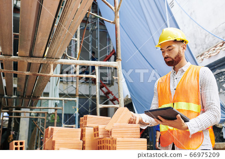 Contractor checking bricks 66975209