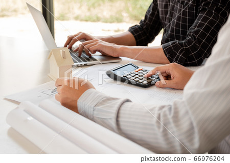 A team of confident architects working together in the office talking about construction 66976204