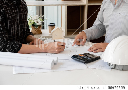 A team of confident architects working together in the office talking about construction and home design projects 66976269