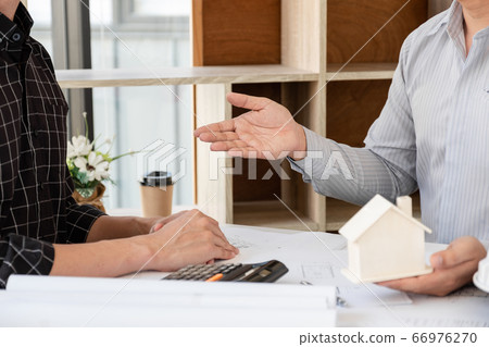 A team of confident architects working together in the office talking about construction and home design projects 66976270