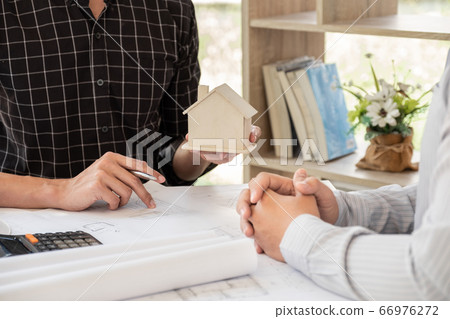 A team of confident architects working together in the office talking about construction and home design projects A team of confident architects working together in the office talking about construction and home design projects 66976272