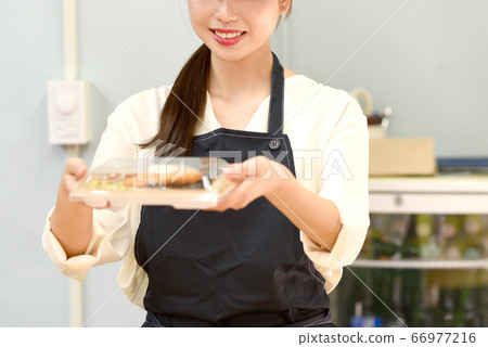 A female clerk giving a lunch 66977216