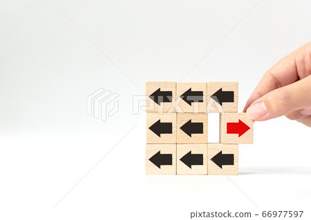 Hand chosen wooden block with red arrow facing the opposite direction black arrows 66977597