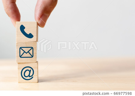 Hand putting wooden block cube symbol telephone, email, address 66977598