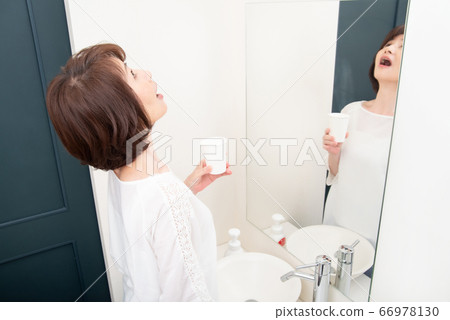 Senior woman gargling Senior woman gargling 66978130