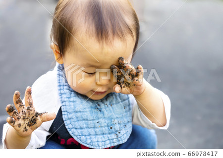 Play in the sandbox Baby rubbing his hands with the sand Rub his eyes with his dirty hands Play in the sandbox Baby rubbing his hands with the sand Rub his eyes with his dirty hands 66978417