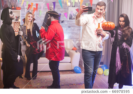 Spooky zombie and witch are taking a selfie Spooky zombie and witch are taking a selfie 66978595
