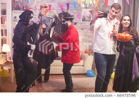 Beautiful witch holding a pumpkin at halloween party Beautiful witch holding a pumpkin at halloween party 66978596