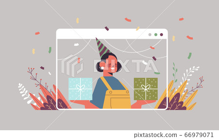 woman in funny festive hat celebrating online birthday party girl in computer window holding gift boxes 66979071