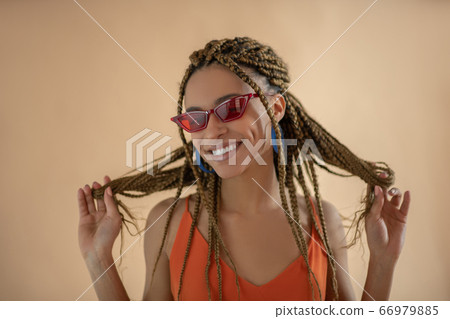 Smiling young African American playing with her dreadlocks 66979885