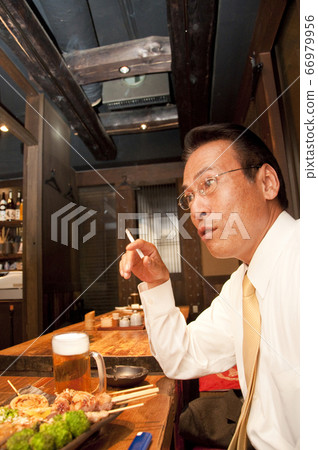 Businessman smoking a cigarette 66979956