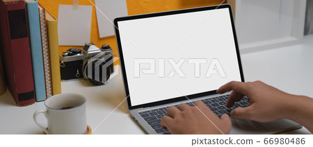 Male hands typing on mock-up laptop above home Male hands typing on mock-up laptop above home 66980486