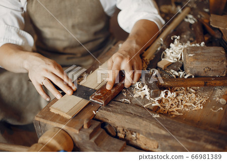 Handsome carpenter working with a wood Handsome carpenter working with a wood 66981389