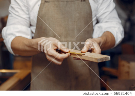 Handsome carpenter working with a wood 66981404