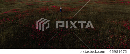 Woman walking on green grass in park Woman walking on green grass in park 66981673