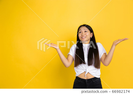 Portrait of young asian woman isolated on yellow studio background 66982174