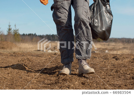 Legs of a volunteer carrying a bag in her hands Legs of a volunteer carrying a bag in her hands 66983504