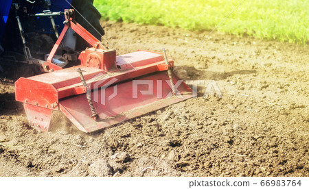 Tractor with milling machine loosens, grinds and mixes ground. Field preparation for new crop planting. Cultivation equipment. Grinding and loosening soil, removing plants and roots from past harvest. 66983764