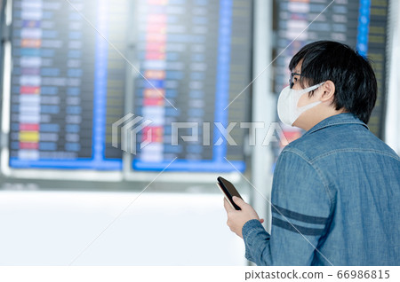 Asian man tourist wearing mask in airport terminal Asian man tourist wearing mask in airport terminal 66986815