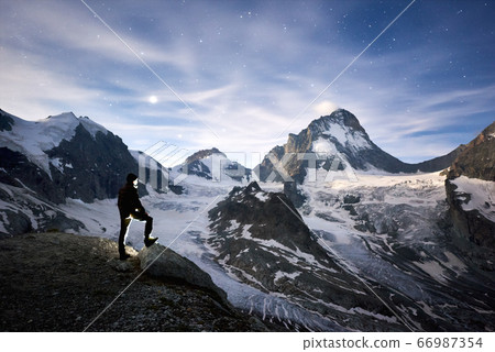 Traveller enjoying incredible starry night in the mountains in Switzerland Alps Traveller enjoying incredible starry night in the mountains in Switzerland Alps 66987354