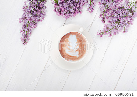 Lilac, coffee with latte art on light wooden Lilac, coffee with latte art on light wooden 66990581