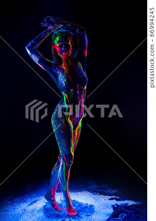 Female model with colorful ultraviolet body in dark 66994245