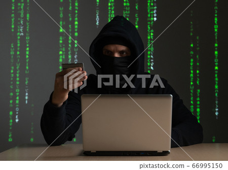 Computer hacker with credit card stealing data from a laptop concept for network security, identity theft and computer crime Computer hacker with credit card stealing data from a laptop concept for network security, identity theft and computer crime 66995150