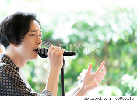 Vocalist singing at an outdoor festival 66996119